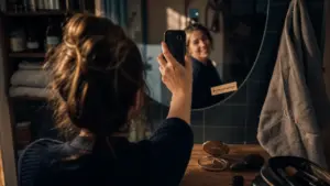 Selfie en publicité : personne souriante devant miroir de salle de bains